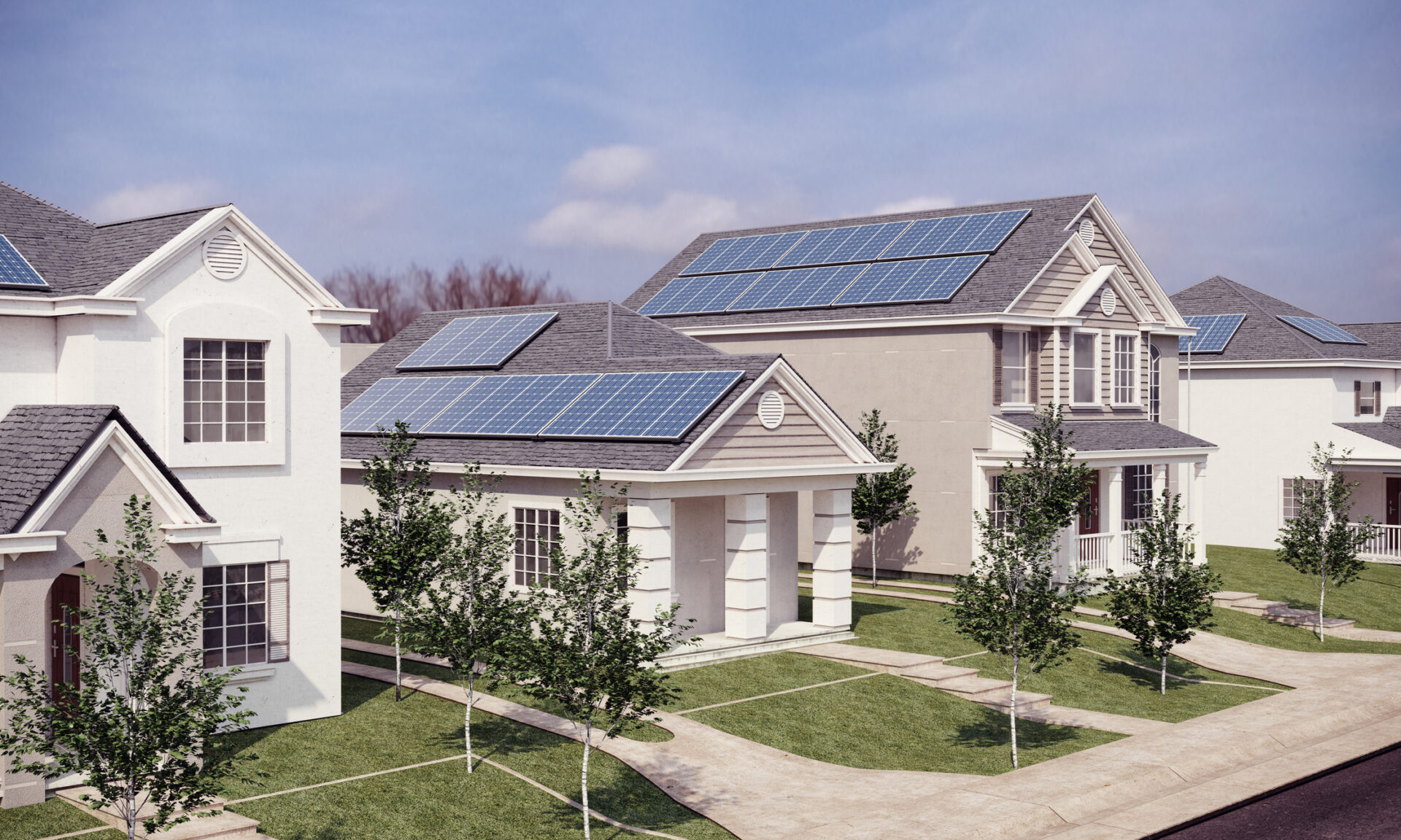 Suburban neighborhood with modern houses featuring solar panels on roofs, surrounded by green lawns and trees, under a clear, blue sky. No people visible.